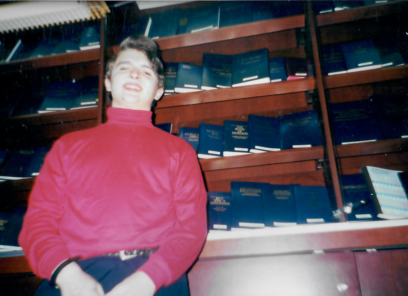 Matthew Sheffield pictured with a shelf filled with Book of Mormon texts